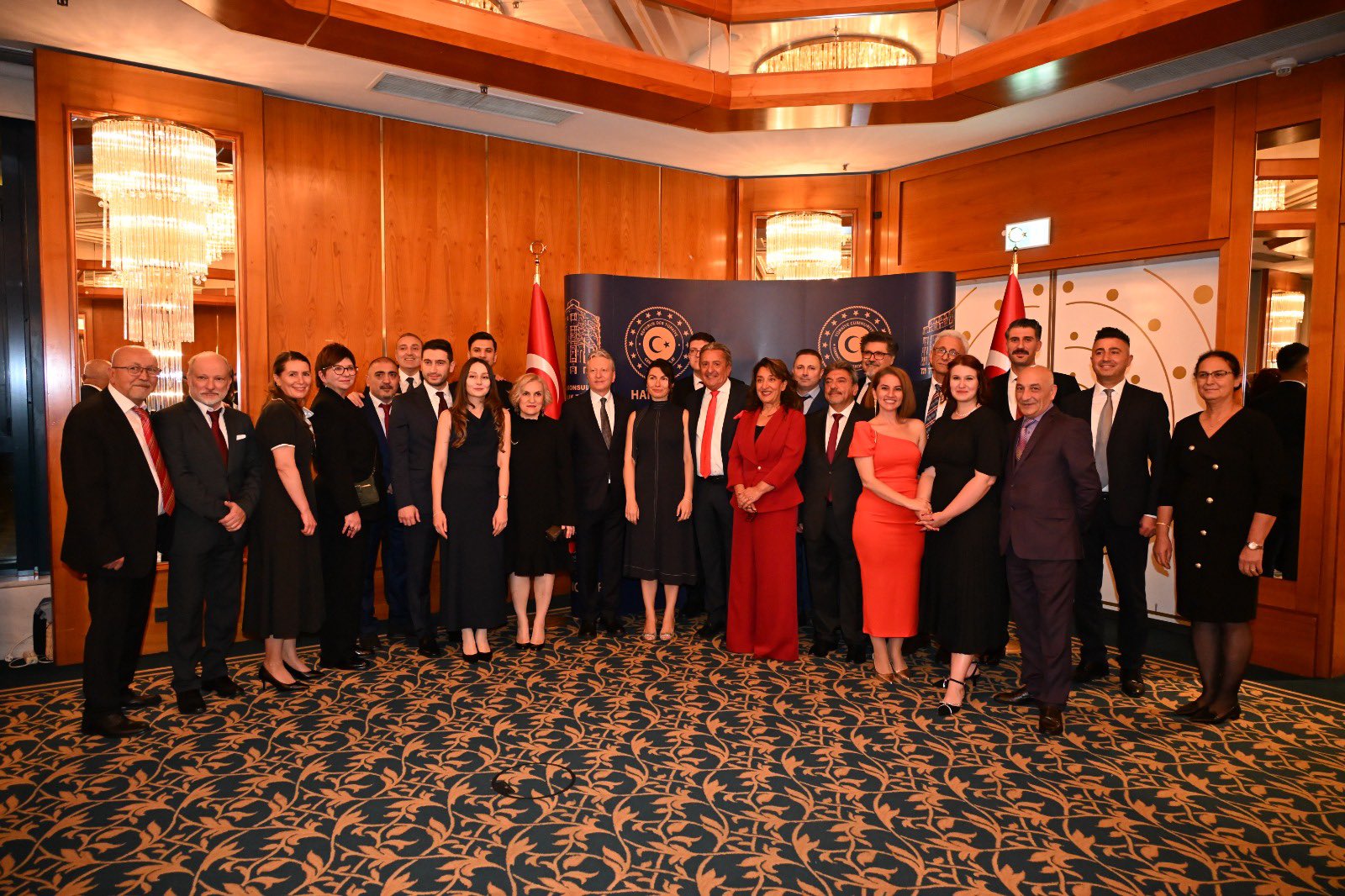 Guests attending the reception pose for a group photo in front of a Hannover Consulate General backdrop