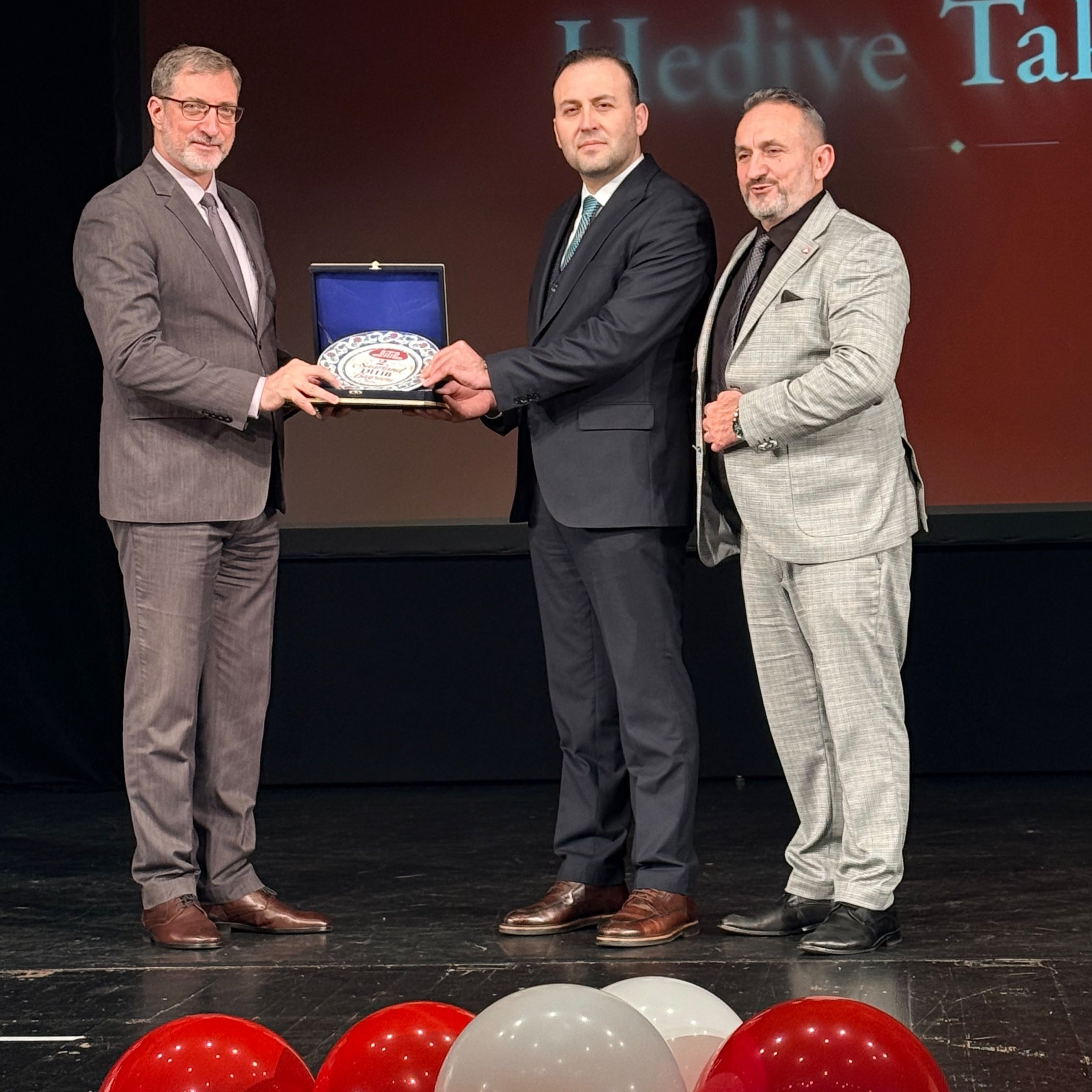 A plaque presentation on stage at the 2nd DİTİB Saarland Bayram