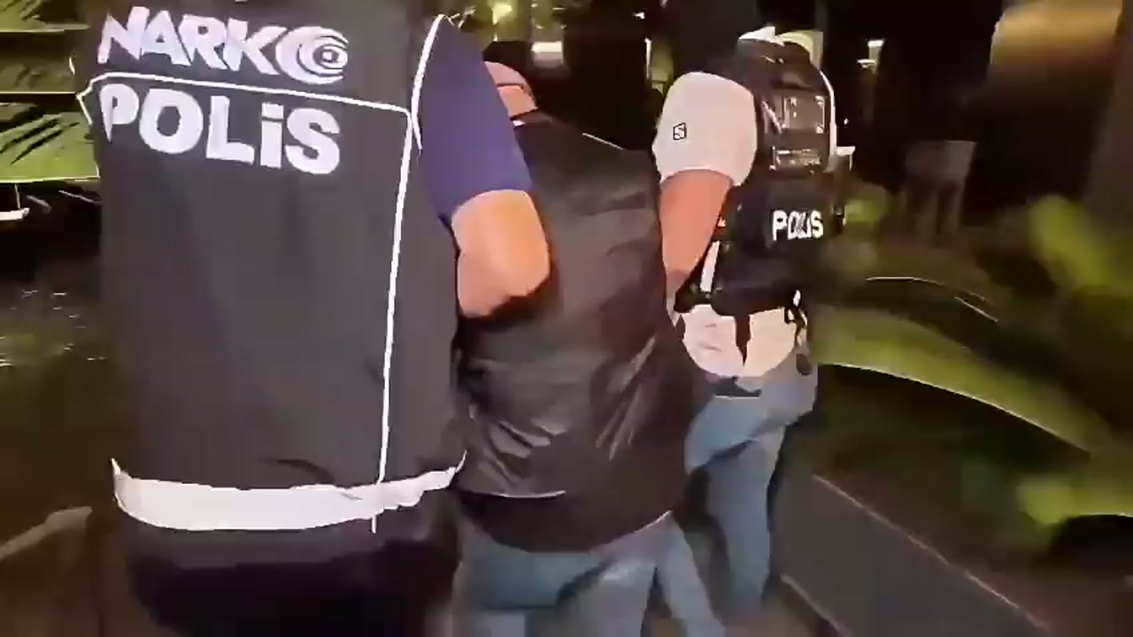Narkotik polisleri bir şüpheliyi götürüyor
