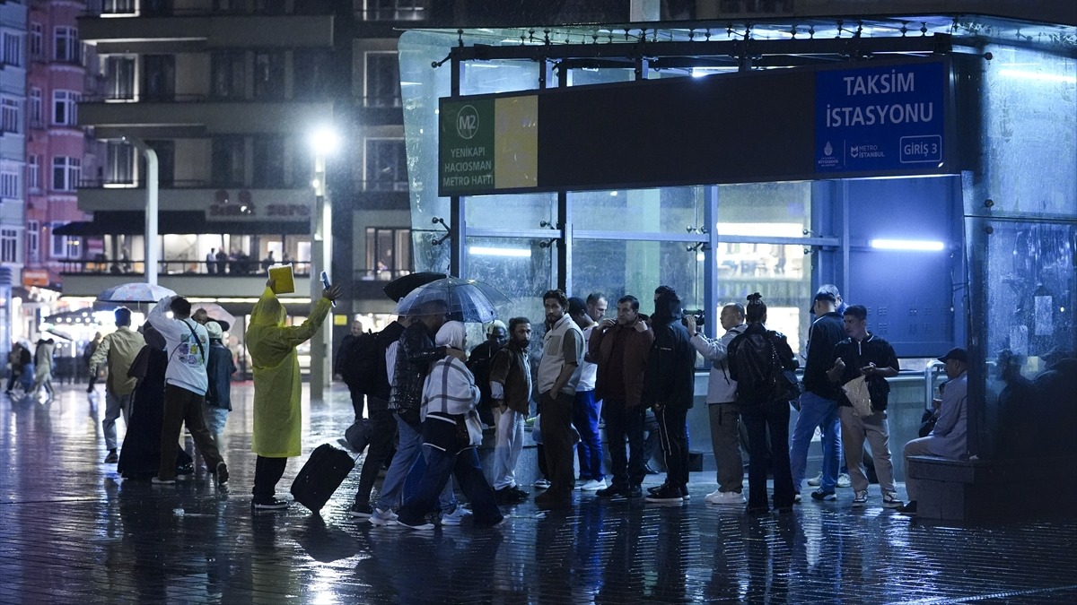 Yağış altında toplu taşıma için sıra bekleyen yolcular