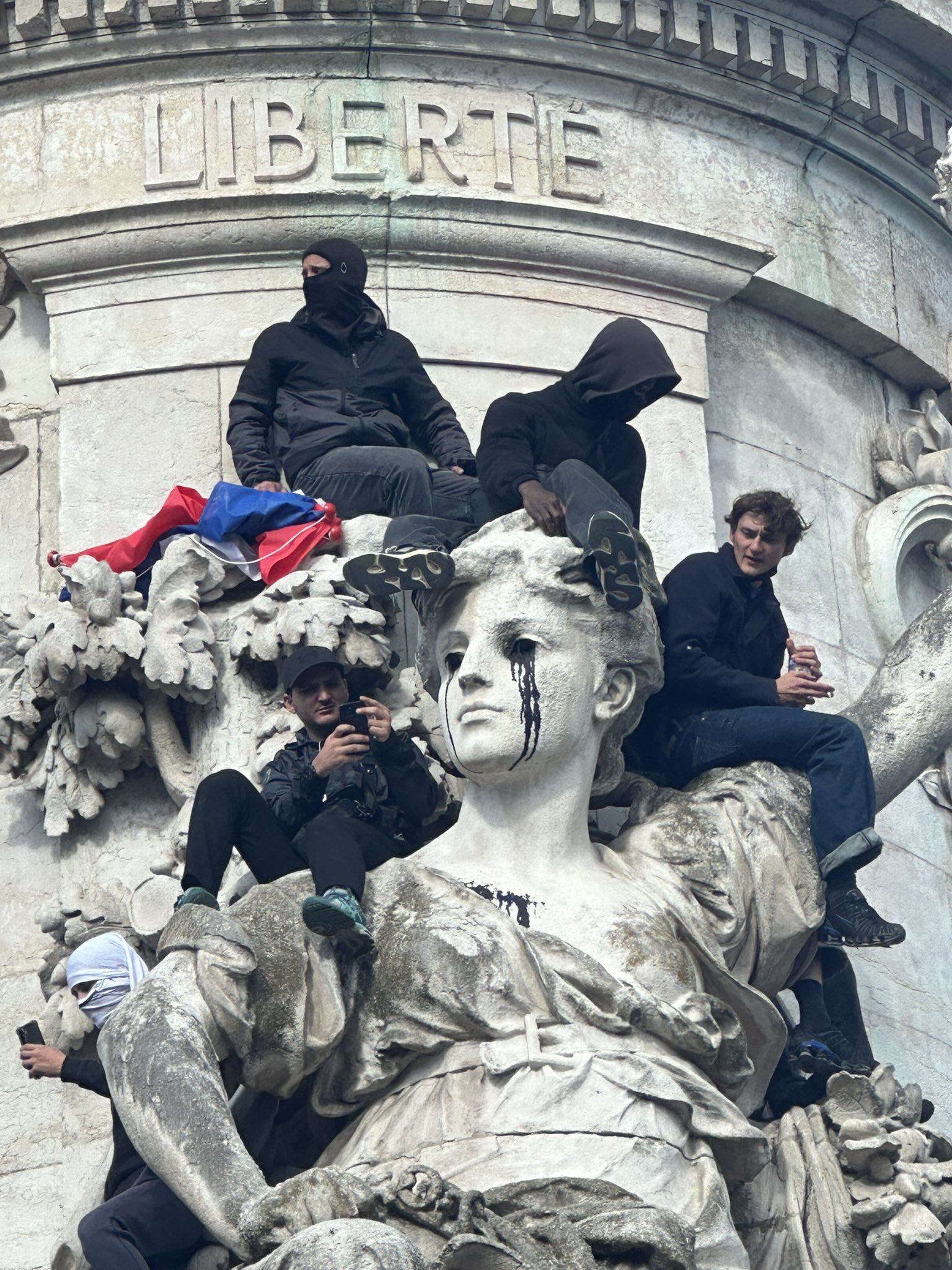 Protesters climb the Monument to the Republic in Paris