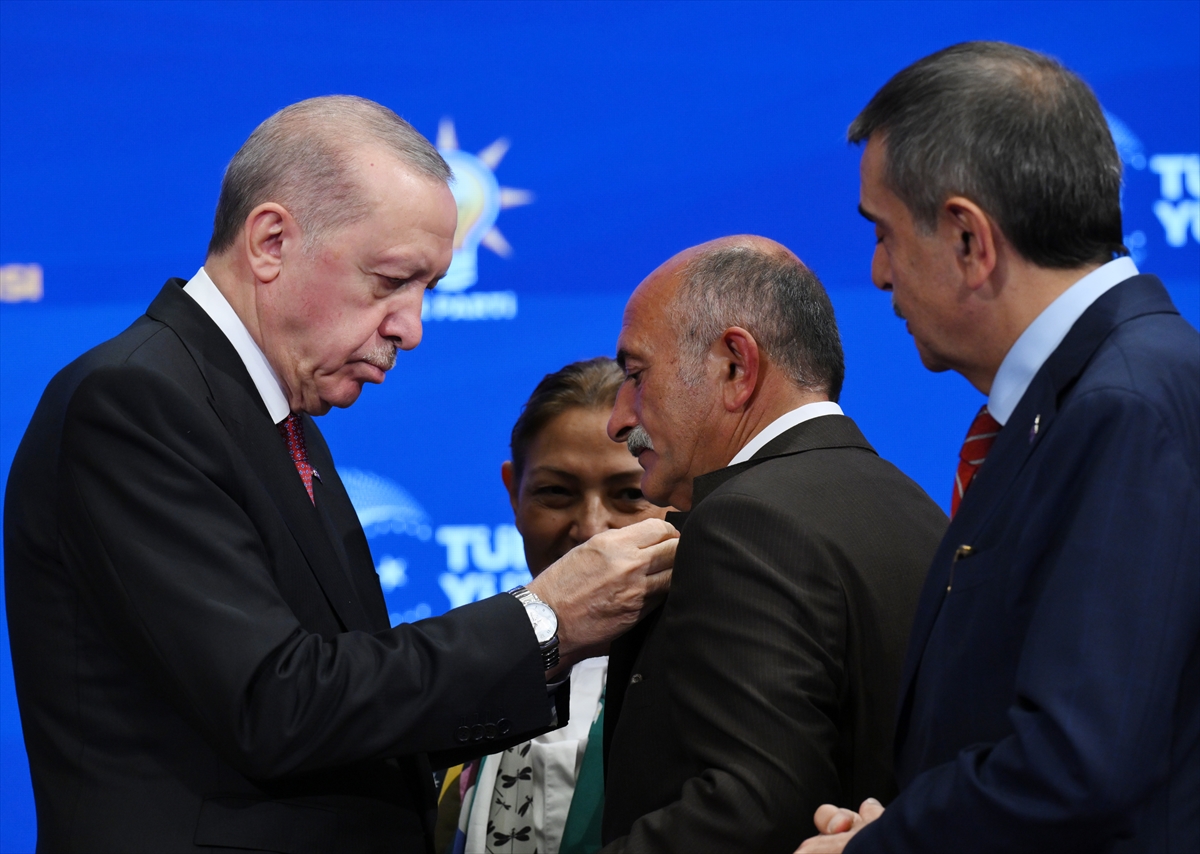 Erdoğan, belediye başkanlarından birine rozet takıyor