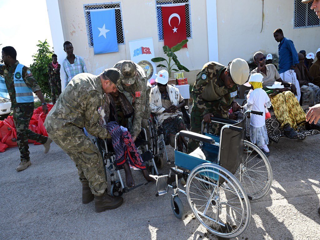 Türk askerleri gazilere tekerlekli sandalye teslim ediyor