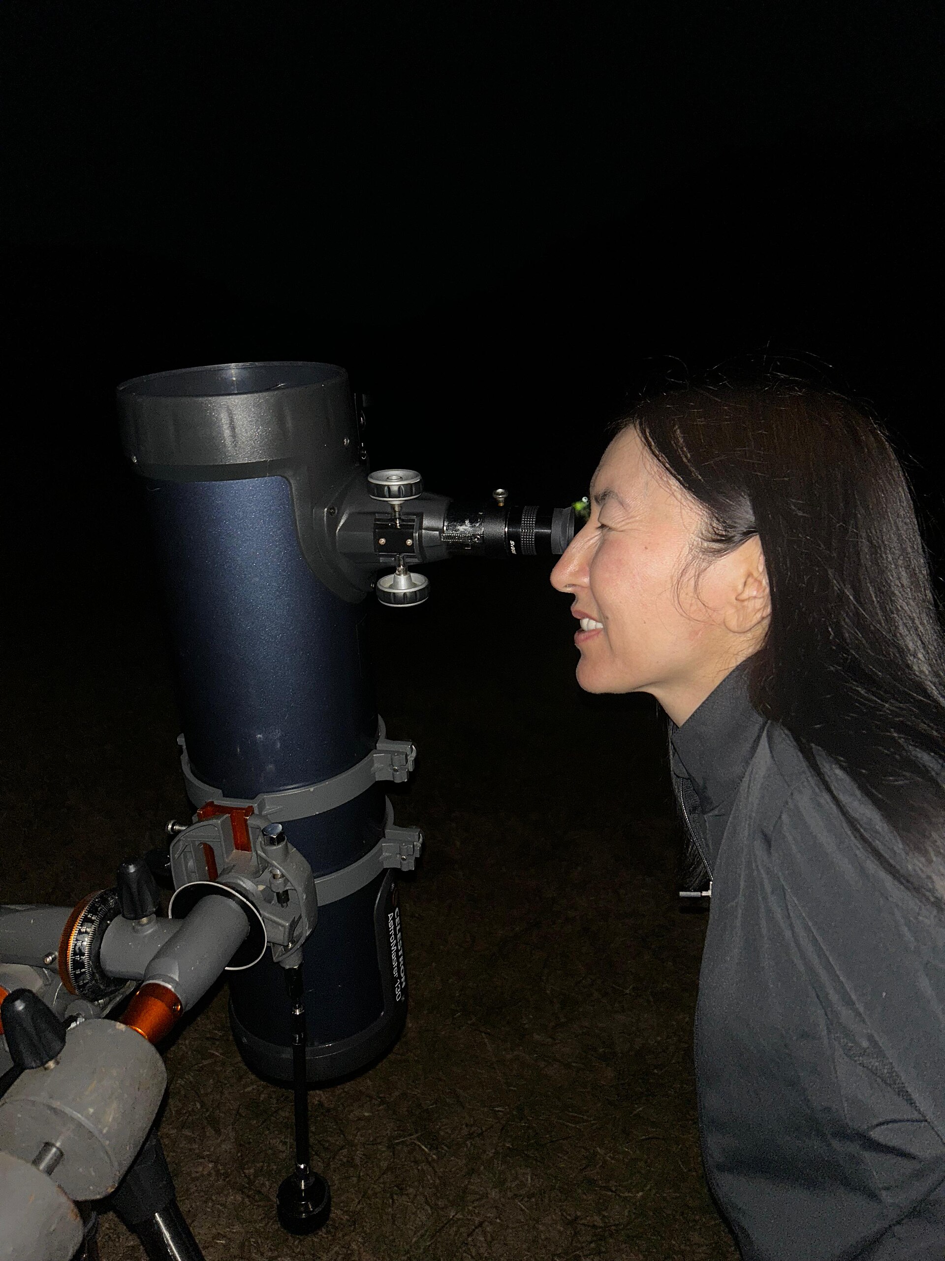 A stargazer observing Saturn through a telescope