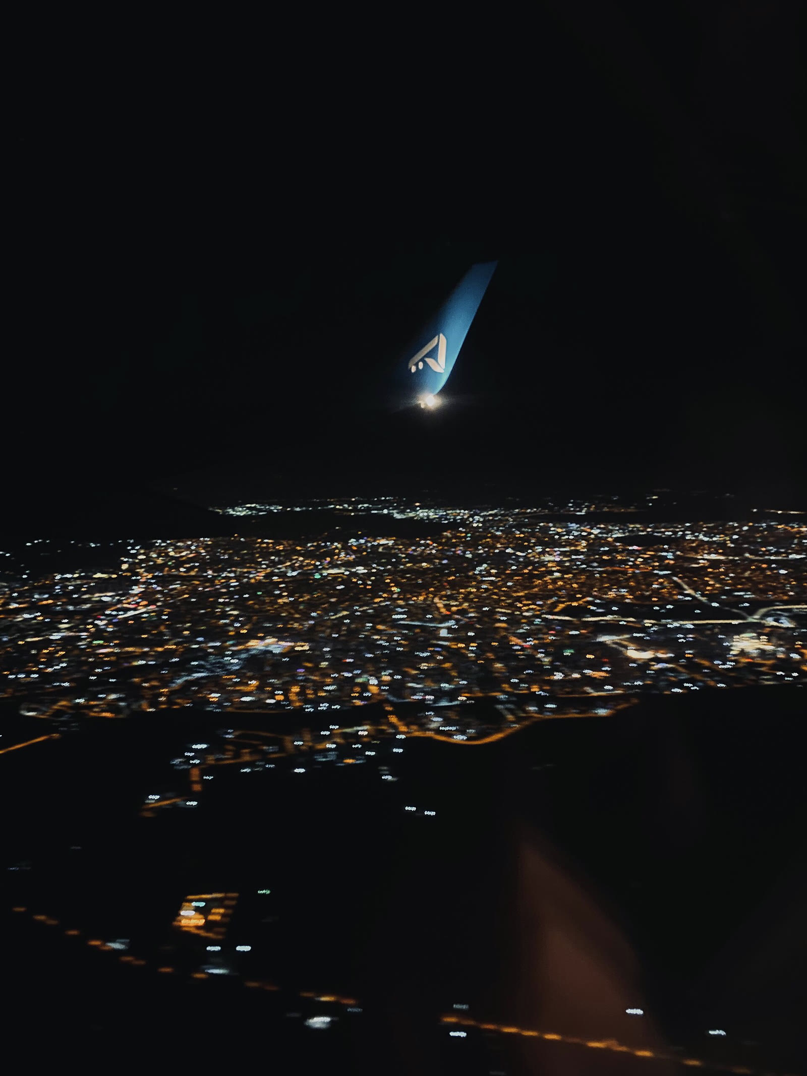 Gece uçuşunda uçak kanadından şehir görünümü (temsili)