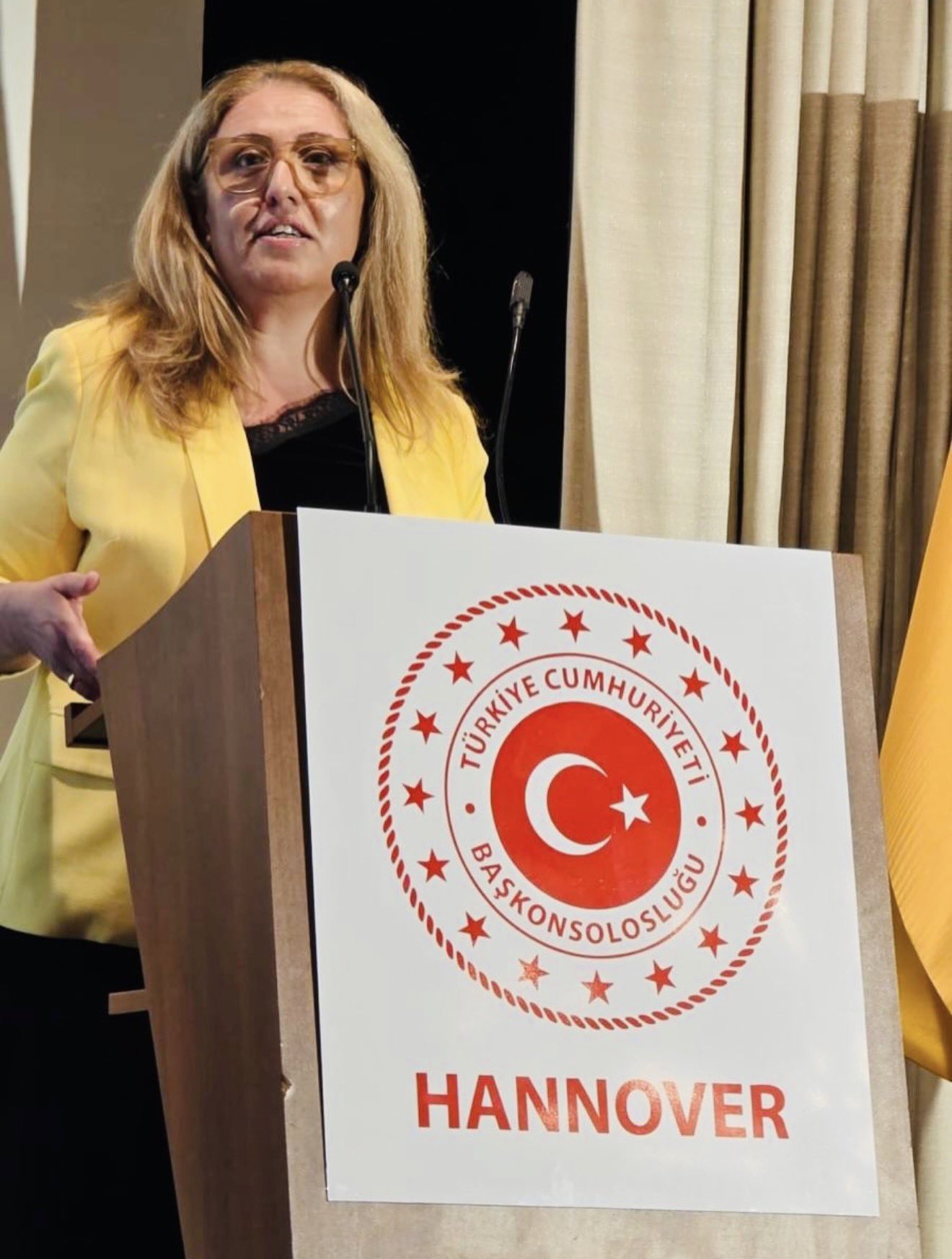 A guest delivers a speech at the podium during the Hannover Consulate General reception